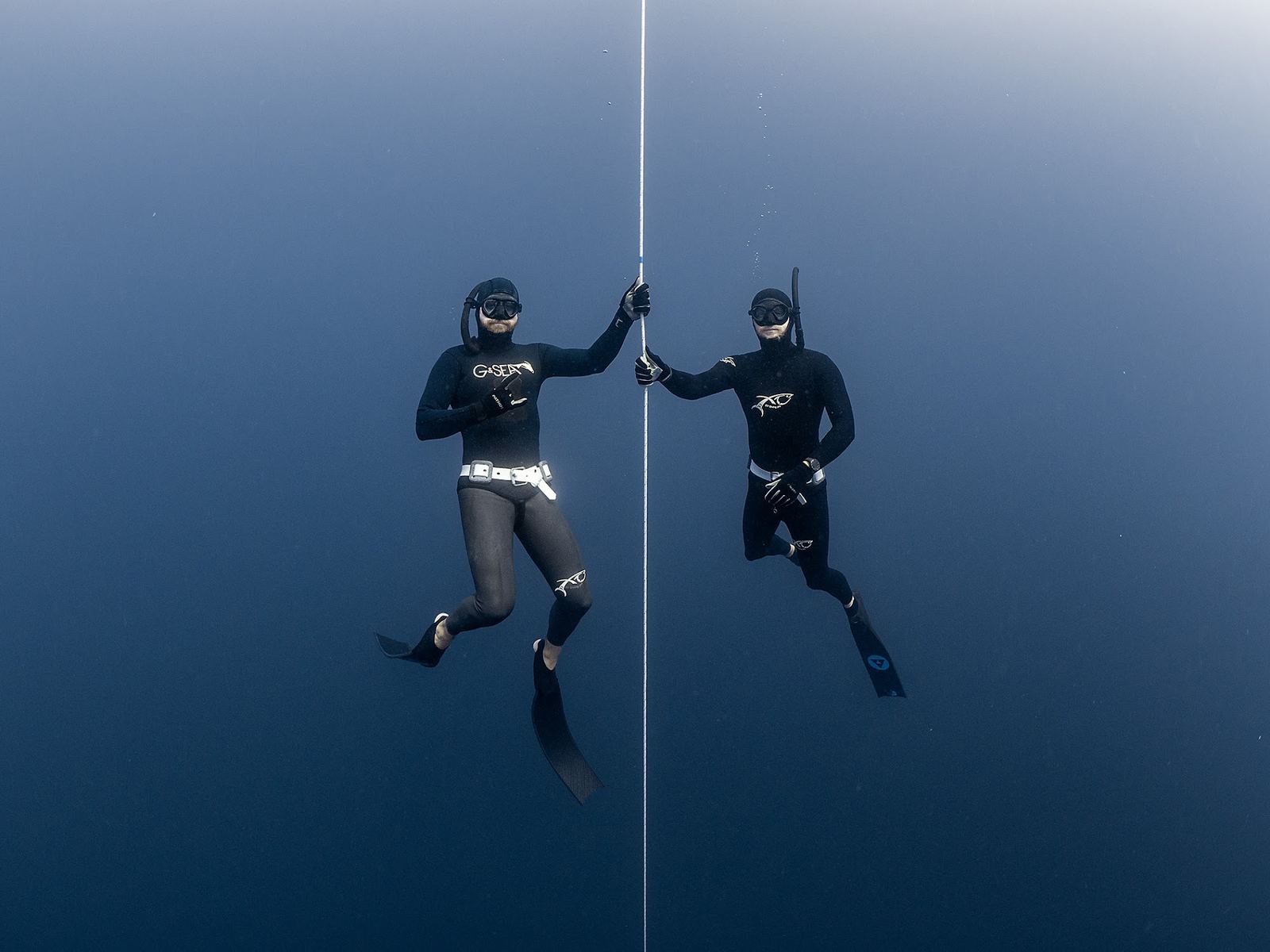 Two freedivers meeting on the dive line